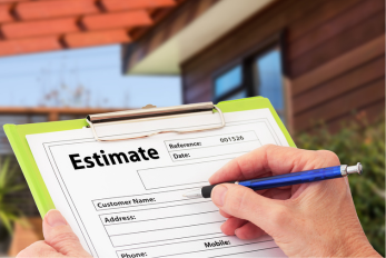 Image of a clipboard with an estimate document on it and a person about to write on the document with a landscaped yard in the background.