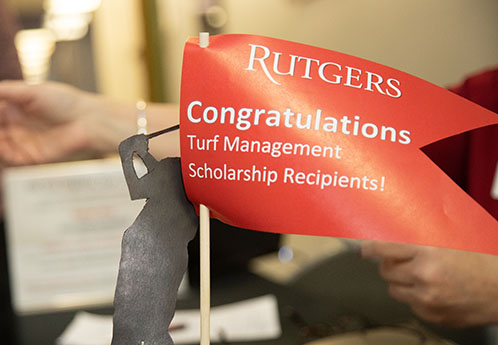 Centerpiece from Rutgers Turf Awards Dinner with red flag reading Congratulations Turf Management Scholarship Recipients!