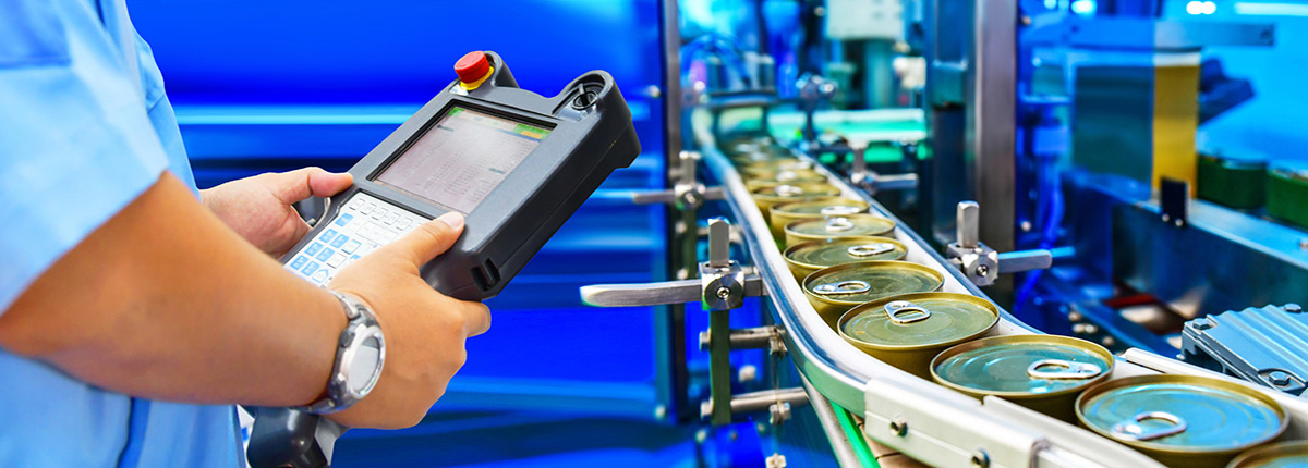 Food Safety Manager checking canned food products on conveyor belt