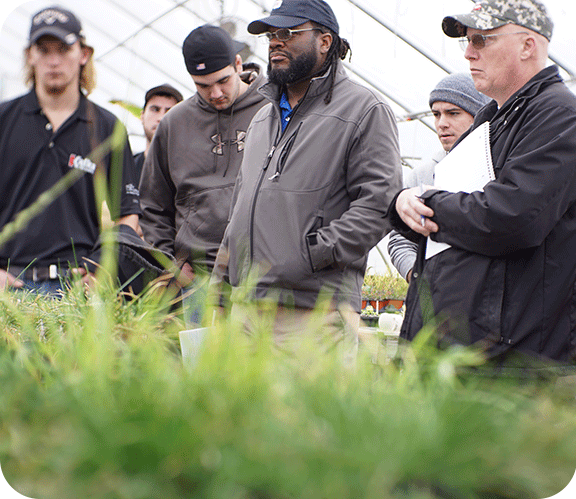 Winter Turf students standing in the greenhouse for a lesson