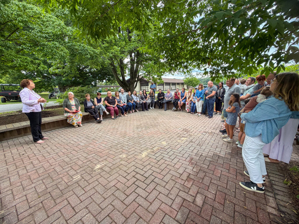 Image showing OCPE Director Karen Plumley speaking about a new teaching garden in honor of Fran Koppell to staff, family, and friends. 