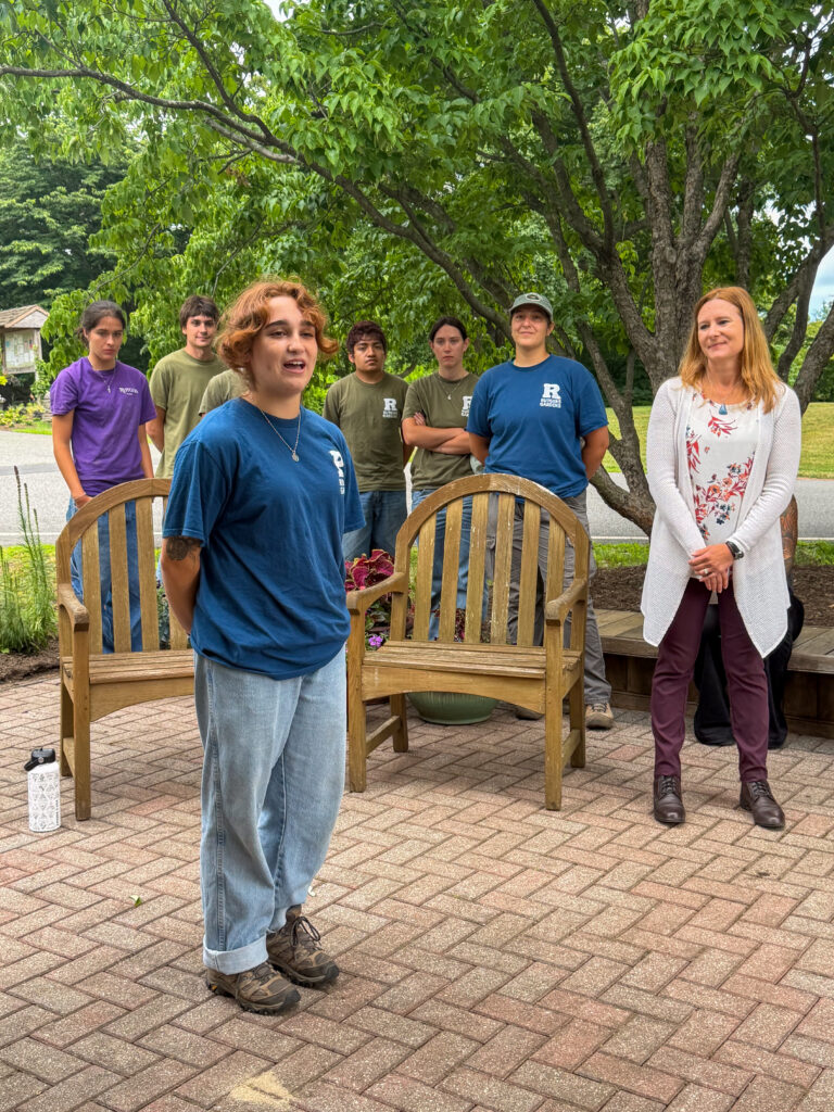 Danielle Lohrman speaks as the student team and Rutgers Gardens director Lauren Erickkson look on