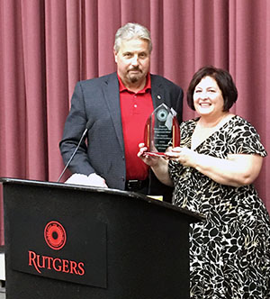 Rutgers Turf alumnus Les Carpenter, Jr. receives the Professional Excellence Award from Senior Program Coordinator Fran Koppell