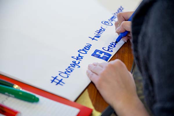 Student draws a Facebook logo on a poster as part of the hands-on activities for Improving Your Public Communication Skills