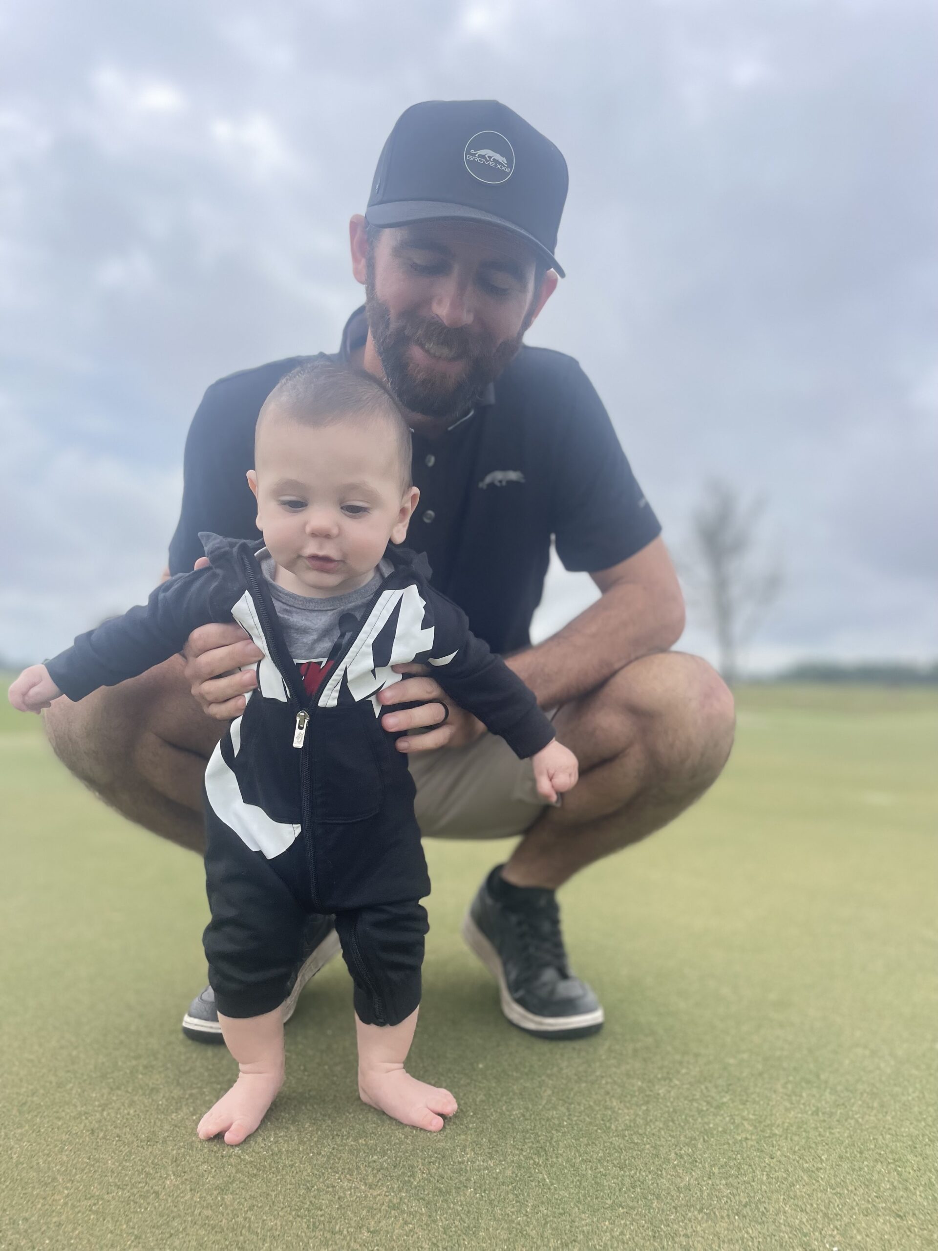 Photo of Tyler Robb, alumni of the Rutgers two-year turf management certificate program, and his son Cy