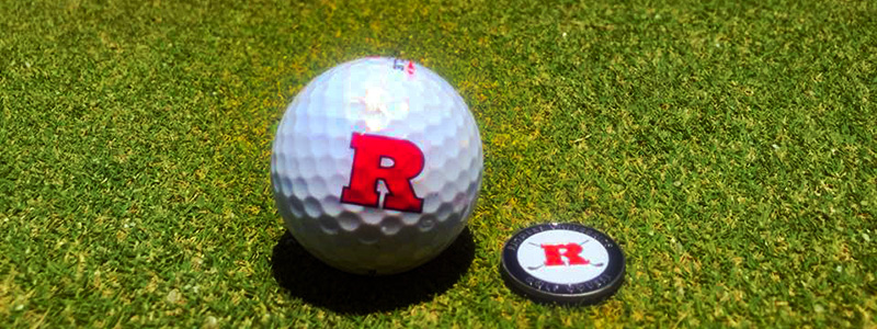 Rutgers golf ball and challenge coin on turfgrass