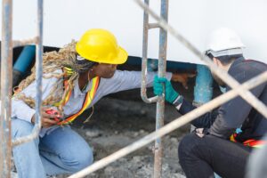 Two construction workers discuss water pipe and wastewater pipes system at the building site.