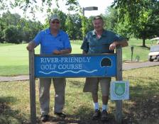 Thomas Grigal and Richard Evans behind Quail Brook Golf Course's River-Friendly Golf Course sign
