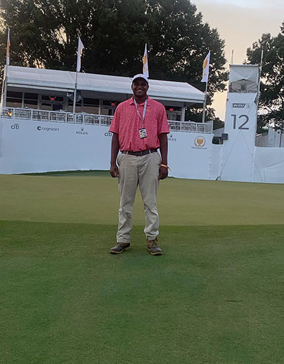 Travis Campbell standing on golf course green