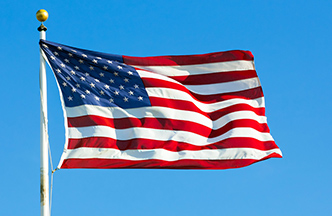 American flag with blue sky behind it