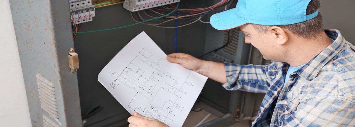 Electrician with Circuit Diagram near Distribution Board