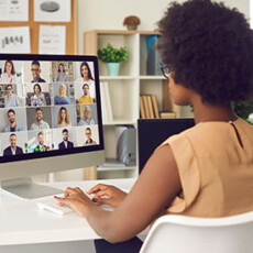 <a href="/leadership-communication">Leadership & Communication</a> Woman typing on keyboard and looking at computer screen showing online meeting