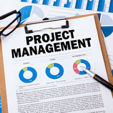 <a href="/leadership-communication/project-management-35-hour">Project Management</a> Paper titled Project Management with charts on clipboard next to glasses and pen
