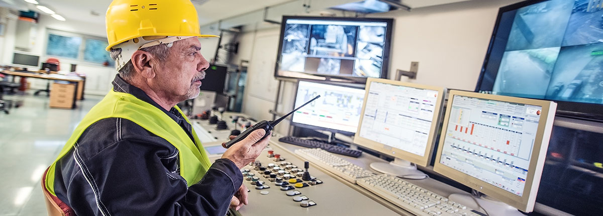 Senior Technician wearing hard hat and holding handheld radio