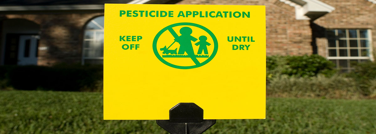 Pesticide application sign on lawn in front of home