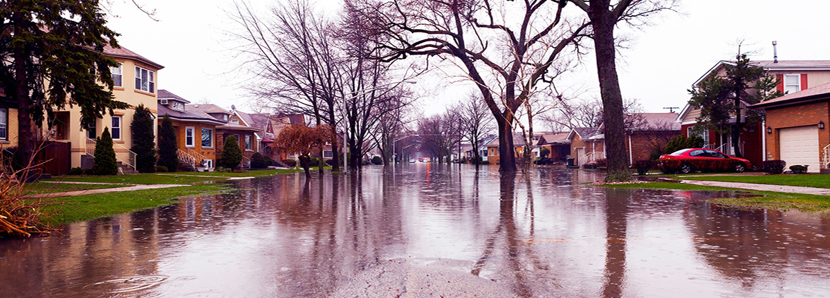 Houses on either side of a flooded roadway