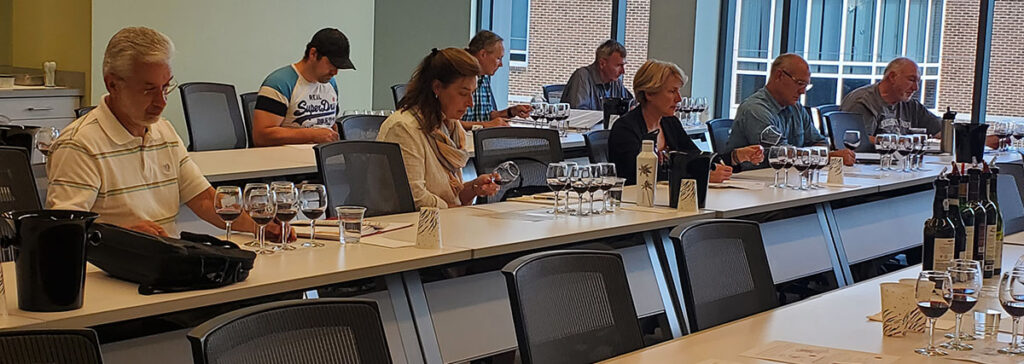 Grape and Wine Science students sitting at long classroom tables with glasses of wine in front of them