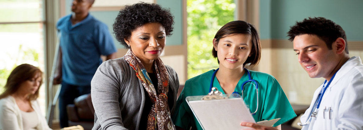 Doctor showing chart to nurse and patient