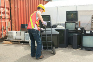 Recycling Worker moving large television with handcart