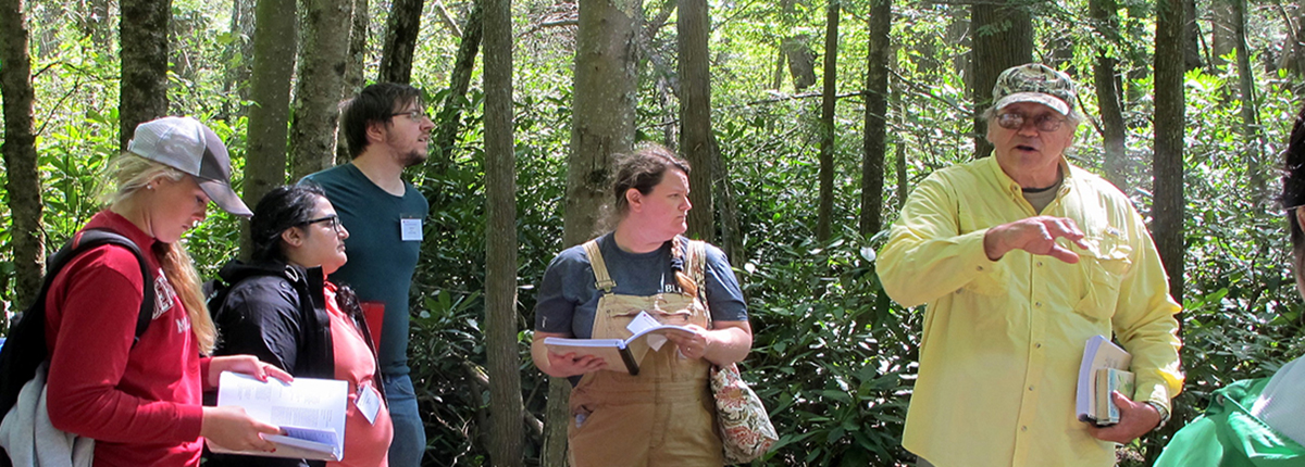 Ralph Tiner instructs students during a wetland class field trip