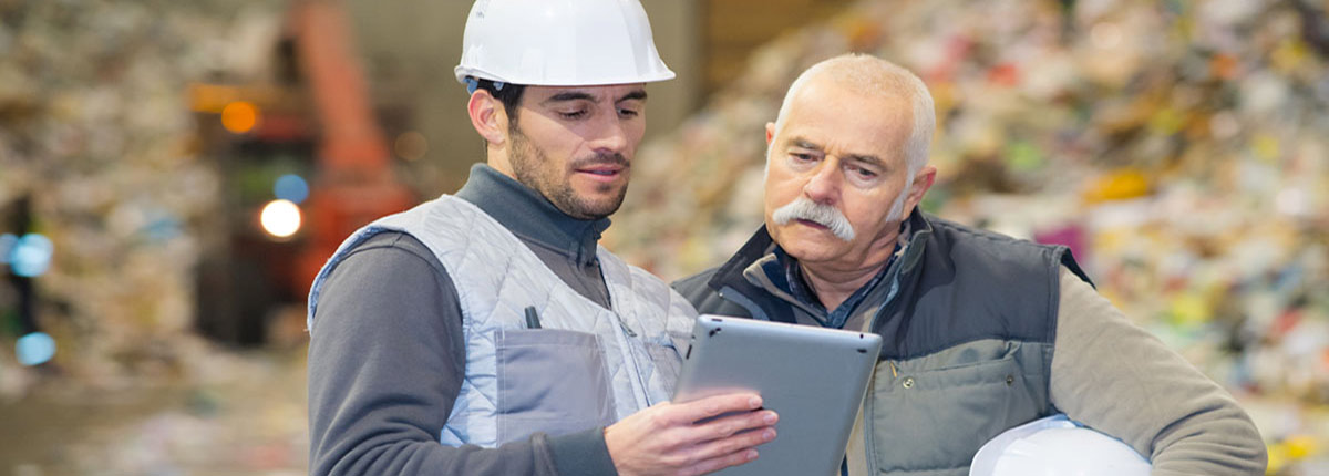 Workers at a recycling center looking at a tablet