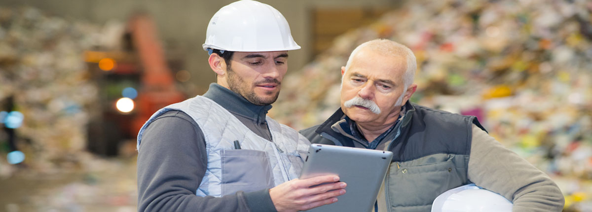 Workers at a recycling center looking at a tablet