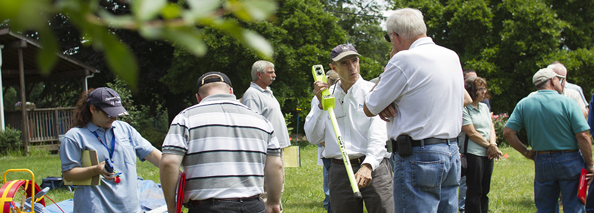 Septic system inspections course instructor demonstrates how to use an inspection tool to a student