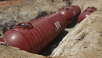 Three red underground fuel storage tanks