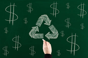 Recycling symbol and dollar signs written on chalkboard