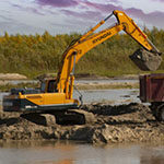 Excavator and dump truck at a wetland construction site
